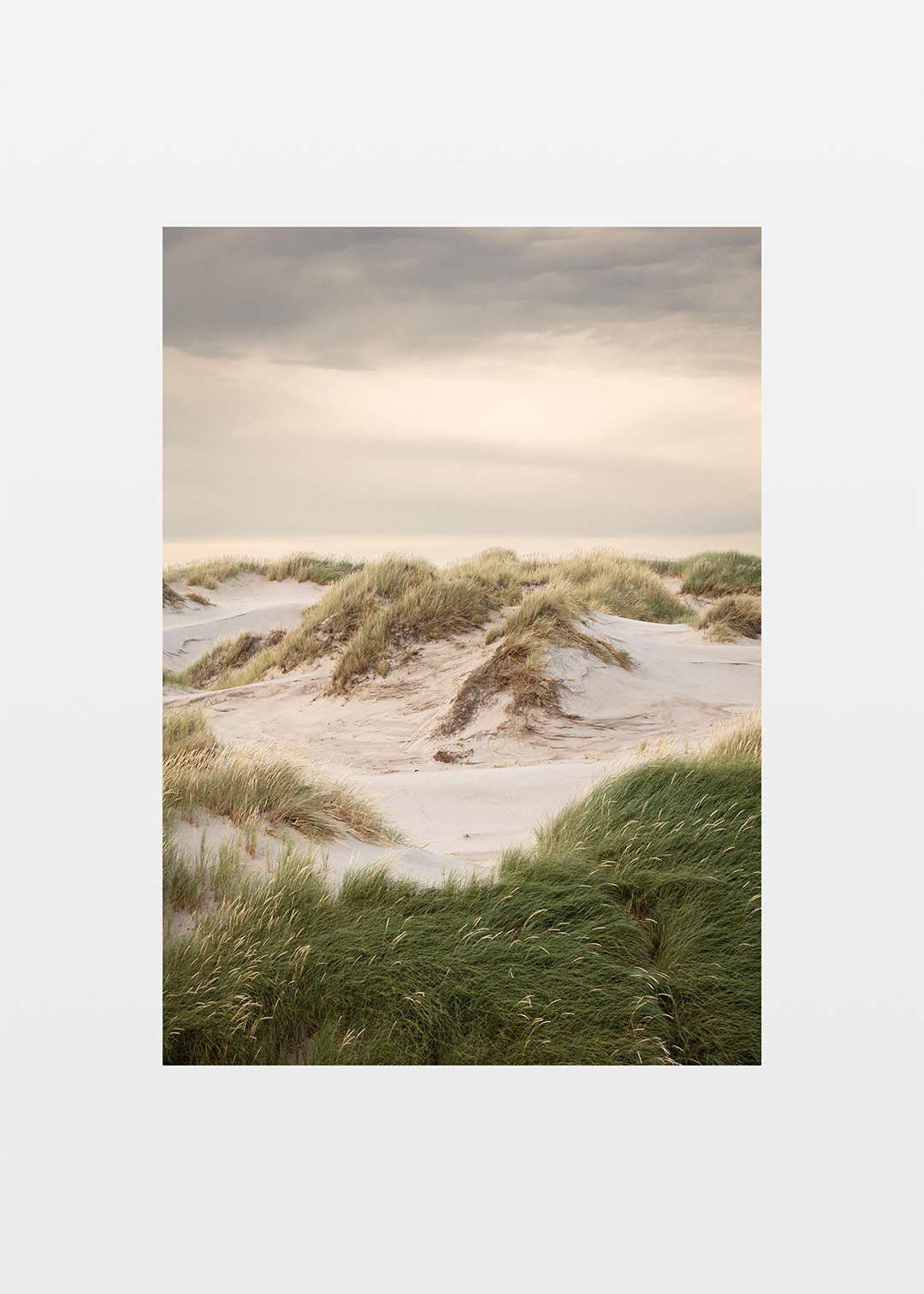 Vestkystens klitter med sand, grønt græs og rolig himmel ved Hvide Sande