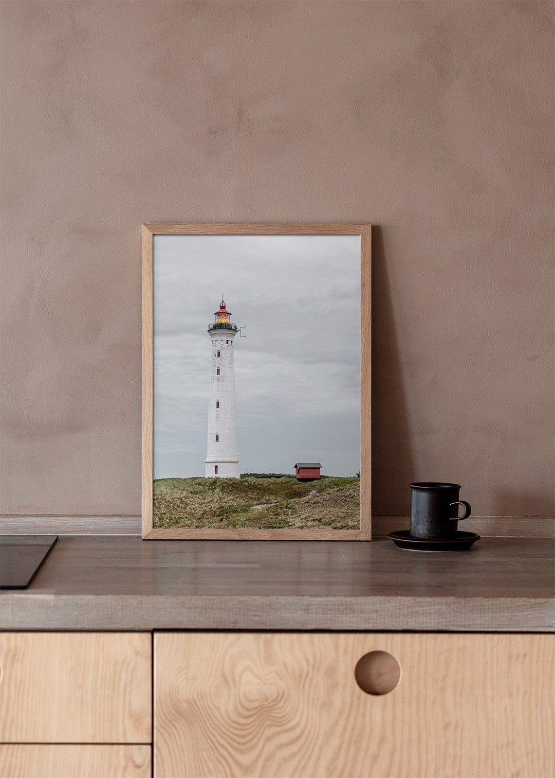 Lyngvig Fyr ved Hvide Sande med klitter, grå himmel og tændt lanterne